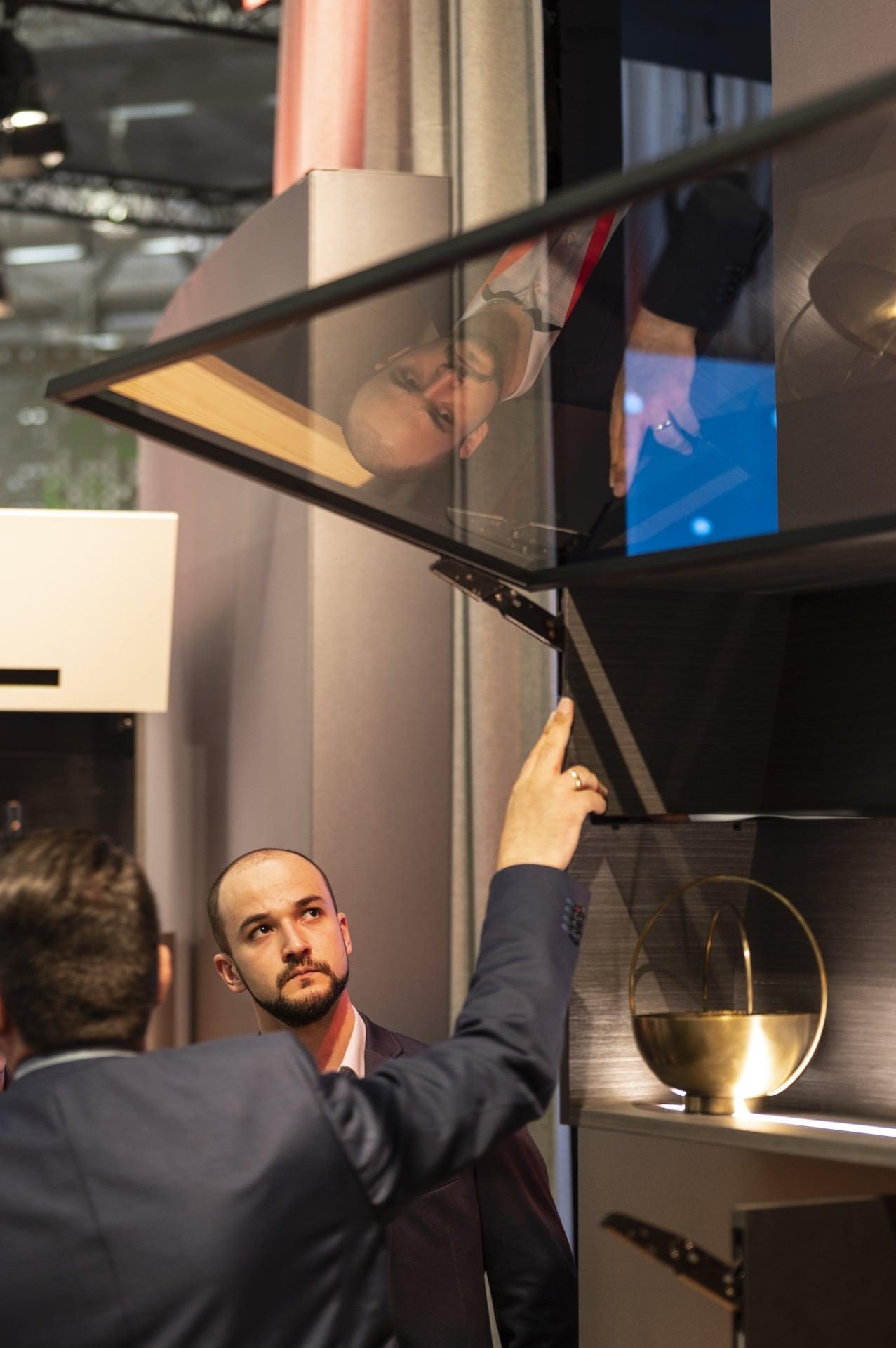 Stay lift with integrated fitting implemented with AVENTOS HKi, an alu frame and a glass front.