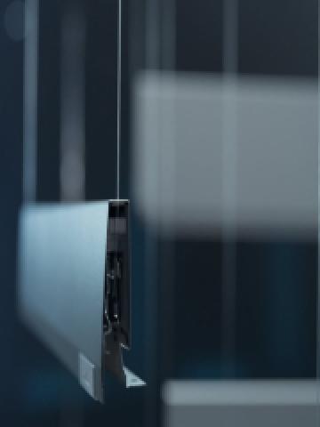 Bir MERIVOBOX çekmece yanağı, odada ince tellerle havada asılı duruyor ve yanağın içindeki teknolojiyi sergiliyor.