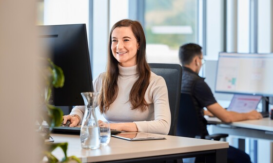 Une experte Blum travaille sur un ordinateur dans son bureau.
